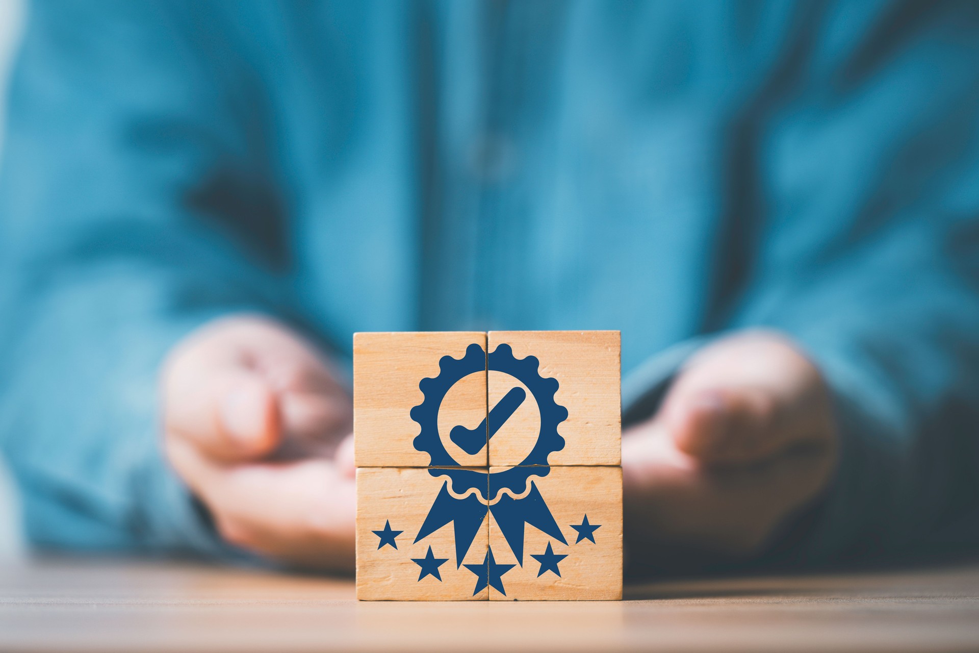 Businessman hand giving and showing the best quality assurance which print screen on wooden block cube with five stars for guarantee product and ISO service concept.