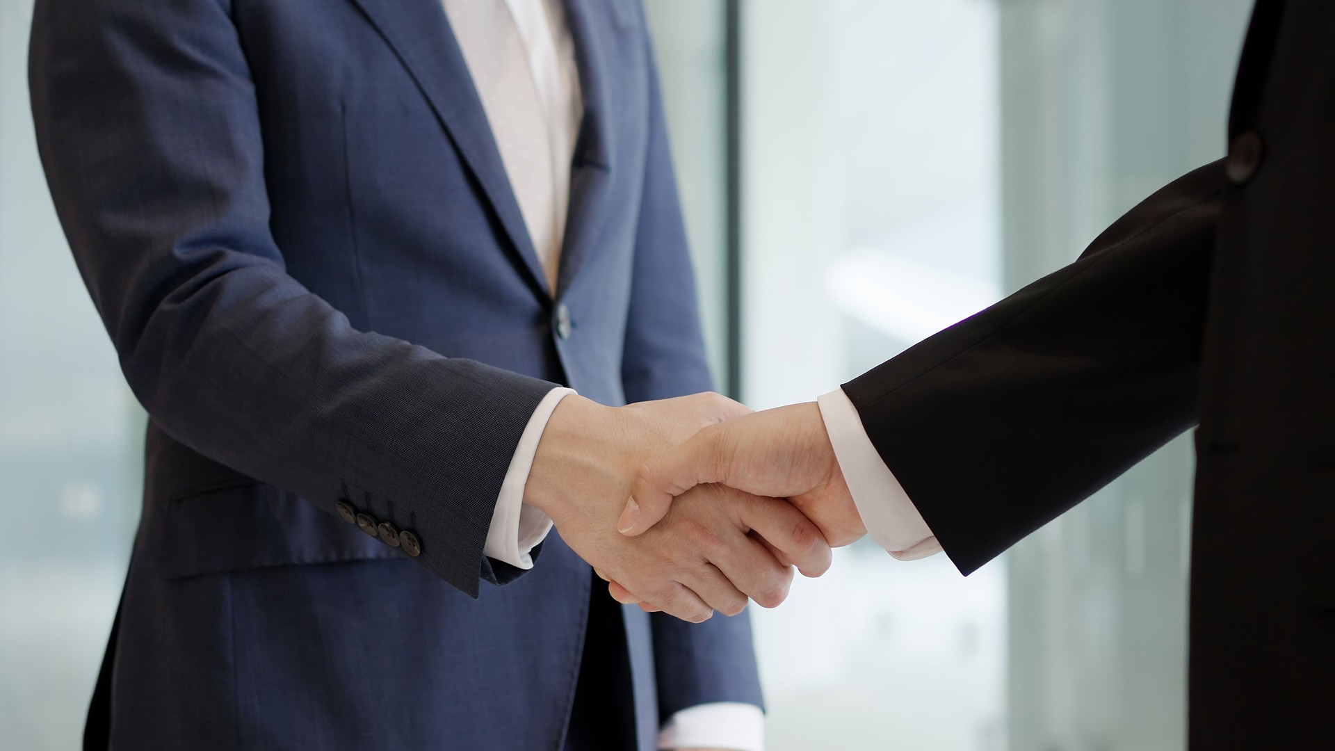 Asian businessmen shaking hands in a lobby